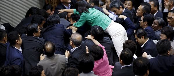 Japonya Parlamentosu’nun üst kanadının silahlı kuvvetlerin yurt dışında savaşa katılmasına onay veren tartışmalı yasayı onayladığı oturumda vekiller birbirine girdi. - Sputnik Türkiye