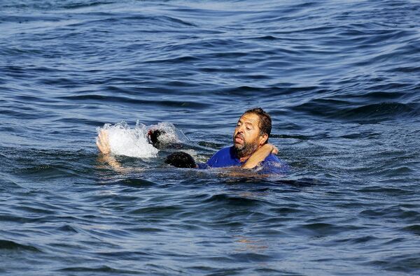 Bu arada Yunanistan'ın Midilli adasına göçmen akını devam ediyor. Nitekim Türkiye'nin Ege sahillerinden denize açılan bir bottaki Afgan göçmenler çarpıcı kareler sunuyor. Karaya yaklaşırken bir an önce kıyıya çıkmak için can yeleğini dahi giymeden denize atlayan Afgan göçmeni, bir Yunan vatandaşı tarafından kurtarıldı. Bu arada Yunanistan'ın Midilli adasına göçmen akını devam ediyor. Nitekim Türkiye'nin Ege sahillerinden denize açılan bir bottaki Afgan göçmenler çarpıcı kareler sunuyor. Karaya yaklaşırken bir an önce kıyıya çıkmak için can yeleğini dahi giymeden denize atlayan Afgan göçmeni, bir Yunan vatandaşı tarafından kurtarıldı. - Sputnik Türkiye