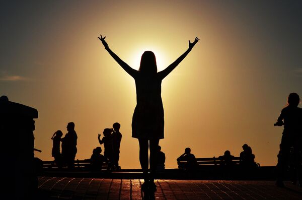 Sivastopol’ün Deniz Sahili’nde genç bir kadın gün batımını izliyor. - Sputnik Türkiye