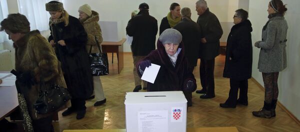 A woman casts her ballot at a polling station during the presidential election in Zagreb - Sputnik Türkiye