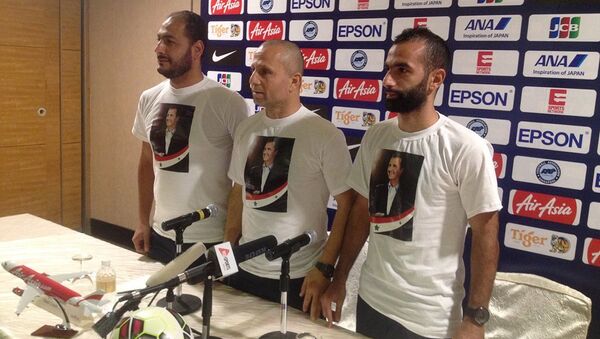 Suriye Milli Takımı, Singapur'la oynayacakları maç öncesi düzenledikleri basın toplantısına Suriye lideri Beşar Esad tişörtleriyle çıktı. - Sputnik Türkiye