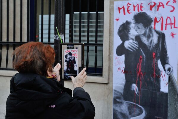 Kadın, Paris’teki grafitinin fotoğrafını çekiyor. - Sputnik Türkiye
