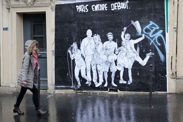 Genç kadın, Paris saldırılarını konu alan bir afişin önünde. - Sputnik Türkiye