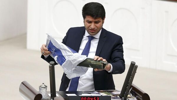 HDP Batman Milletvekili Mehmet Ali Aslan, TBMM Genel Kurulu'nda yaptığı konuşma sırasında, yanında getirdiği lav silahının bir bölümü ile tank mermisinden bir parçayı kürsüden gösterdi. - Sputnik Türkiye