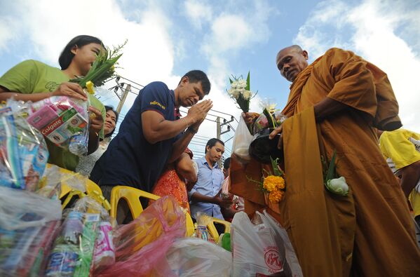 Taylandlı Budist rahip, yeni yıl kutlamaları sırasında yardım malzemeleri topluyor. - Sputnik Türkiye