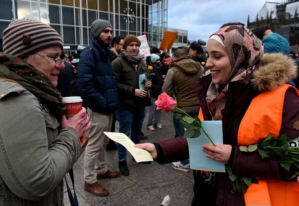 Tunus Gençliği üyeleri, yılbaşı gecesinde yaşananlarla ilgili notlar iliştirilmiş beyaz gülleri Alman kadınlara dağıttı - Sputnik Türkiye
