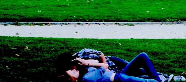 Çimlerde uzanan bir çift. - Sputnik Türkiye