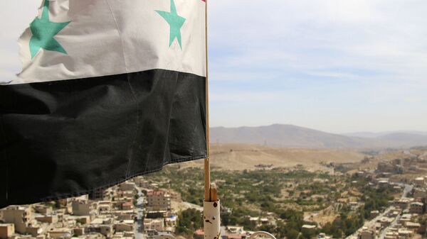 In this photo taken on Sunday, Oct. 18, 2015, a Syrian flag flies above the village of Maaloula, north of Damascus, Syria - Sputnik Türkiye