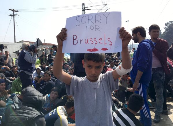 Binlerce sığınmacının haftalardır beklediği Yunanistan'ın Makedonya sınırındaki bir çocuk, Brüksel'de yaşanan saldırıların ardından bir pankart hazırladı: Brüksel için üzgünüm. - Sputnik Türkiye