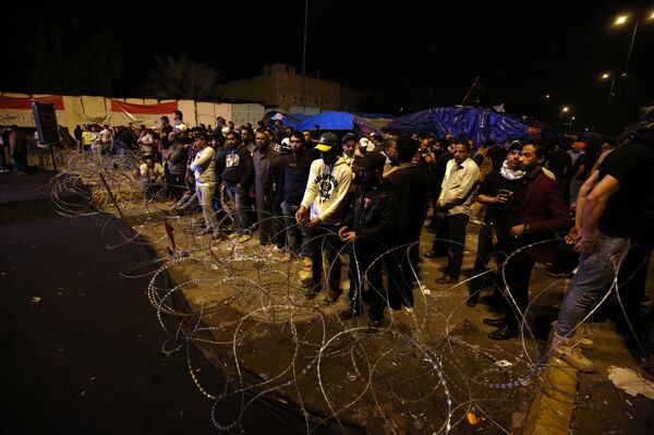 Sadr'ın çağrısı nedeniyle Yeşil Bölge'nin dışında kalan destekçileri, gece boyunca tel örgülerin arkasındaki bekleyişlerini sürdürdü. - Sputnik Türkiye