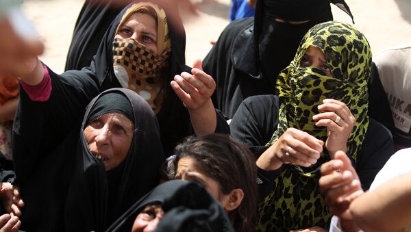 Ramadiye kaça Felluceli kadınlar, barınacak yer yapmak için kullanılan yardım paketlerini beklerken. - Sputnik Türkiye