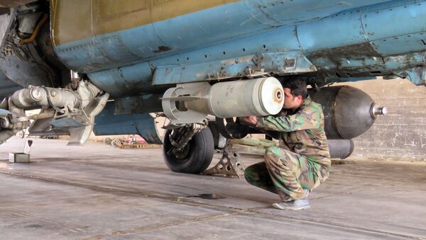 A Syrian army soldier attaches a missile to a jet at Dmeir military airport, 50 km north-east of Damascus, on April 8, 2016 - Sputnik Türkiye