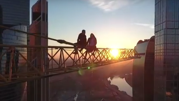 Rusya’nın başkenti Moskova’da adrenalin meraklısı iki kişi hiçbir güvenlik önlemi olmadan bir gökdelenin tepesindeki vince tırmandı. - Sputnik Türkiye