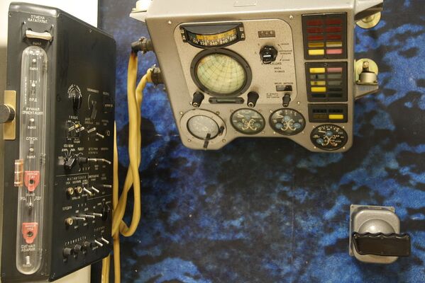 Sovyetler Birliği’ne ait Vostok uzay aracının kabin düzeni. 1961 tarihli fotoğrafta soldan sağa ana santral (ПКРС, PKRS, Roket sistemleri kontrol paneli),  uçuş aygıtları paneli, göstergeler ve sinyal tablosu, roket tepkime kontrol sistemi manuel kontrol çubuğu görülüyor. - Sputnik Türkiye