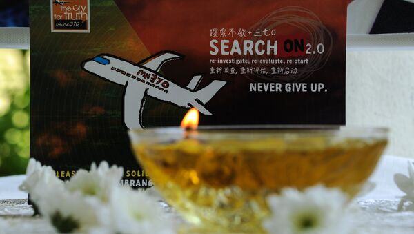 A candle burns a prayer message for passengers of missing Malaysia Airlines flight MH370 in Petaling Jaya on March 8, 2016 - Sputnik Türkiye