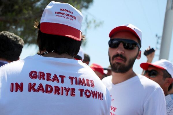 Eyleme Kadriye bölgesi esnafı, bölgenin eski zamanlarını anlatan İngilizce 'Kadriye'de harika zamanlar' yazılı tişört ve şapkalarla geldi.  - Sputnik Türkiye