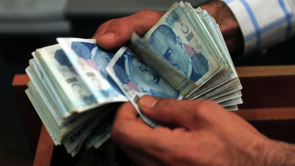 An exchange office worker counts Turkish lira banknotes in Istanbul on June 8, 2015 - Sputnik Türkiye