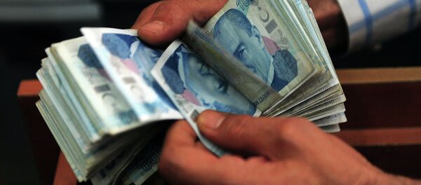 An exchange office worker counts Turkish lira banknotes in Istanbul on June 8, 2015 - Sputnik Türkiye
