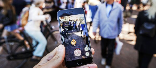 Gamers play with the Pokemon Go application on their mobile phone, at the Grote Markt in Haarlem, on July 13, 2016 - Sputnik Türkiye