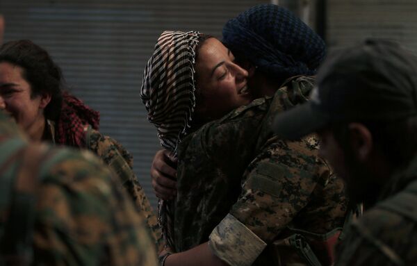 Menbiç'in IŞİD'den kurtarılmasının ardından birbirine sarılan Demokratik Suriye Güçleri kadın askerlari. - Sputnik Türkiye