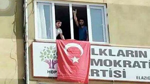 Elazığ Emniyet Müdürlüğü'ne bombalı araçla yapılan saldırının ardından bir grup Rizaye Mahallesi'nde bulunan HDP il binasına girerek pencereye Türk bayrağı astı. - Sputnik Türkiye