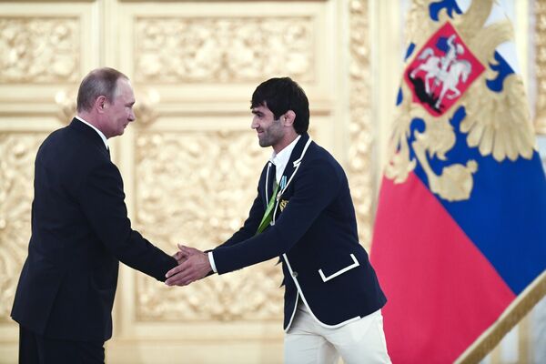 Rusya Devlet Başkanı Vladimir Putin, Rio Olimpiyatları'nda ülkesine ilk altın madalyayı kazandıran judocu Beslan Mudranov ile birlikte. - Sputnik Türkiye