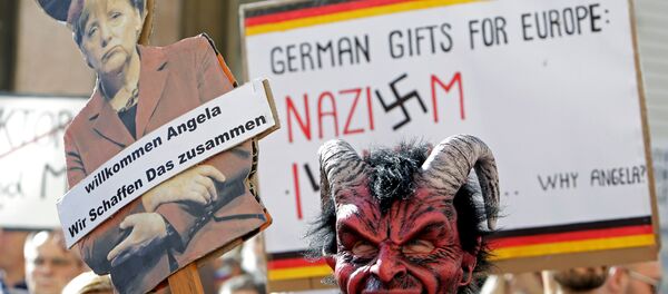 Merkel'i protesto edenler ellerinde 'Almanya'nın Avrupa'ya hediyesi Nazizm ve İslam' ile 'Hoşgeldin Angela, birlikte başarabiliriz' yazılı pankartlar taşıdı. - Sputnik Türkiye