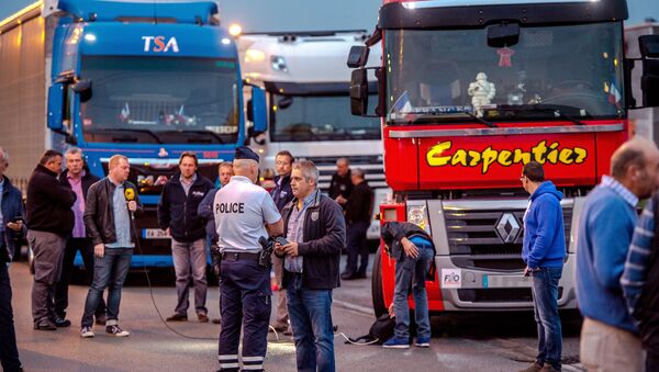 A man speaks with a police officer as a dozen of truck drivers gather in a parking on September 5, 2016 in Loon Plage prior to a slow-down operation on the A16 highway to ask for the dismantling of the so-called Jungle migrant camp in the French northern port city of Calais - Sputnik Türkiye