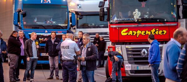 A man speaks with a police officer as a dozen of truck drivers gather in a parking on September 5, 2016 in Loon Plage prior to a slow-down operation on the A16 highway to ask for the dismantling of the so-called Jungle migrant camp in the French northern port city of Calais - Sputnik Türkiye