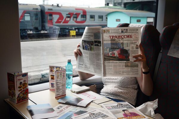Lastoçka (Kırlangıç) trenin yolcusu Transsib gazetesini okuyor. - Sputnik Türkiye