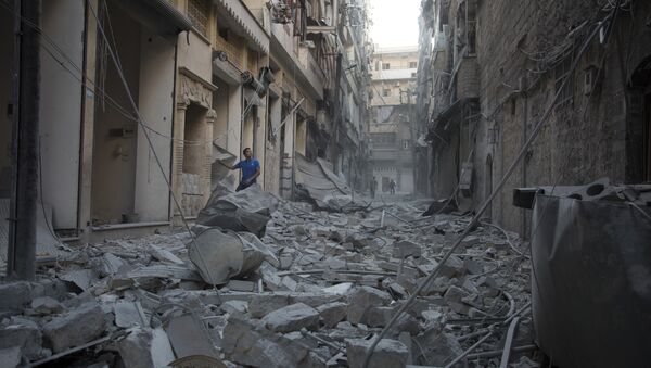 A Syrian man stands in the rubble of destroyed buildings following an air strike in Aleppo's rebel-controlled neighbourhood of Karm al-Jabal. (File) - Sputnik Türkiye