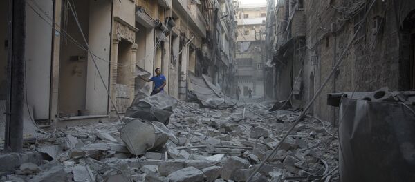 A Syrian man stands in the rubble of destroyed buildings following an air strike in Aleppo's rebel-controlled neighbourhood of Karm al-Jabal. (File) - Sputnik Türkiye