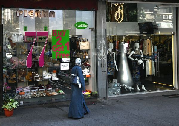 Lübnan’ın Beyrut şehrindeki mağaza vitrinin önündeki kadın. - Sputnik Türkiye