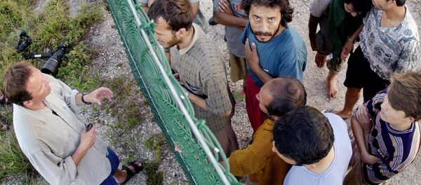 Asylum seekers at Australia's detention center on the island of Nauru gather on one side of a fence to talk with international journalists about their journey that brought them there. - Sputnik Türkiye