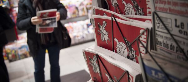 A man holds the latest edition of French satirical weekly newspaper Charlie Hebdo at a train station in Paris on February 25, 2015 - Sputnik Türkiye