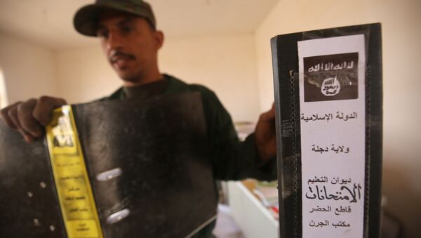 Irak ordusundan bir asker Musul yakınlarında bulunan IŞİD'e ait dokümanı gösteriyor - Sputnik Türkiye