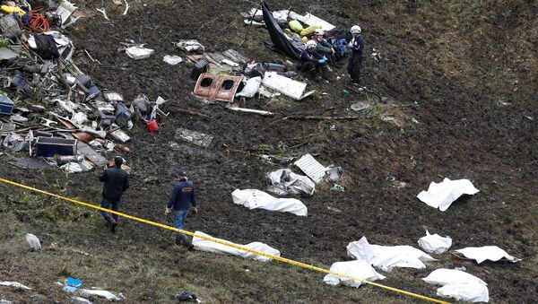 Rescue workers walk next to bodies from the wreckage of a plane that crashed into the Colombian jungle with the Brazilian soccer team Chapecoense onboard near Medellin, Colombia - Sputnik Türkiye