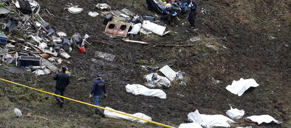 Rescue workers walk next to bodies from the wreckage of a plane that crashed into the Colombian jungle with the Brazilian soccer team Chapecoense onboard near Medellin, Colombia - Sputnik Türkiye