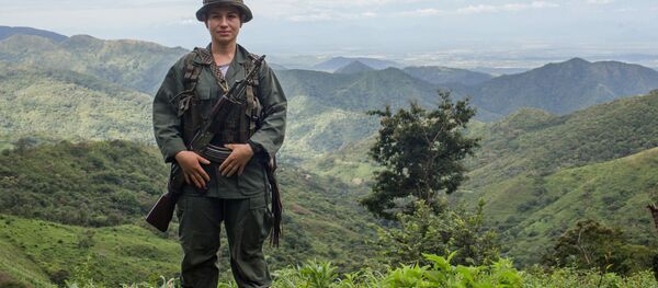Kısa bir süre sonra silahlarını teslim edecek olan bir Farc gerillası - Sputnik Türkiye