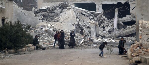 Halep'in kuzetindeki El-Rai'de Suriyeliler bina enkazlarının önünde oturuyor - Sputnik Türkiye