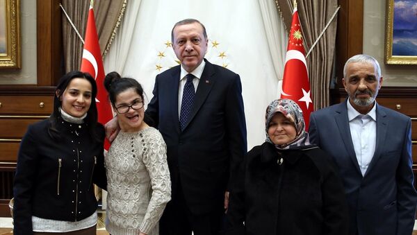 Cumhurbaşkanı Recep Tayyip Erdoğan, portresini çizerek, Twitter üzerinden kendisine ulaşan engelli Gülşah Yağmur Yazıcı (sol 2) ile anne Sebahat Yazıcı ve baba Şenol Yazıcı ile Cumhurbaşkanlığı Külliyesi'nde görüştü. - Sputnik Türkiye