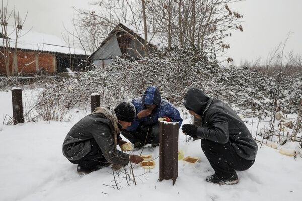 Yardım kurumlarının dağıttığı yemekler için uzun kuyruklar oluşturan sığınmacılar karınlarını da dışarıda doyuruyor. - Sputnik Türkiye
