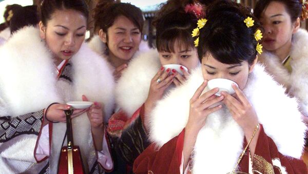 Tour bus guides clad in kimono drink sake after praying at Meiji Shrine to celebrate their coming of age in Tokyo (File) - Sputnik Türkiye