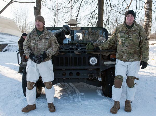 Letonya’da NATO savaş araçları ve silahlar gösterişinde ABD Silahlı kuvvetleri Hummer zırhlı aracının yanında askerler. - Sputnik Türkiye