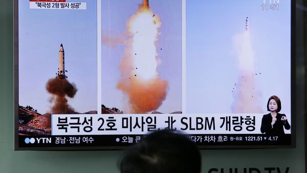 Güney Koreliler televizyondan Kuzey Kore'nin yaptığı balistik füze denemesi ile ilgili haberleri izliyor. - Sputnik Türkiye