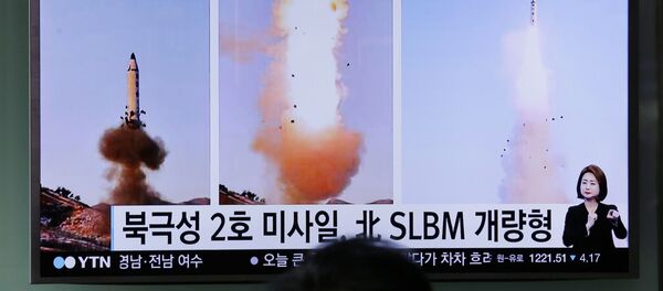 Güney Koreliler televizyondan Kuzey Kore'nin yaptığı balistik füze denemesi ile ilgili haberleri izliyor. - Sputnik Türkiye