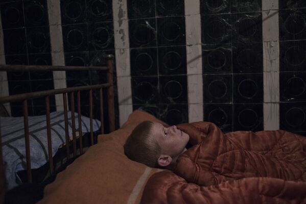 Donbass’ta yıkılan okullardan birinin bodrumuna sığınan bir çocuk. - Sputnik Türkiye