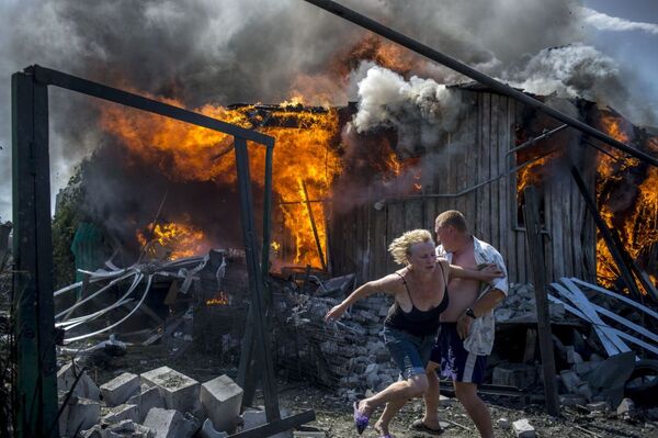 Lugansk bölgesinde yerel sakinler yangından kurtulmaya çalışıyor. - Sputnik Türkiye