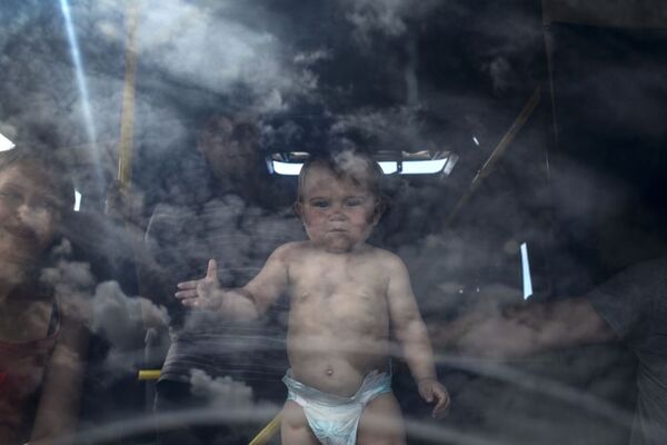 Lugansk bölgesinde İzvarino sınır kapısında bekleyen otobüsteki çocuk. - Sputnik Türkiye