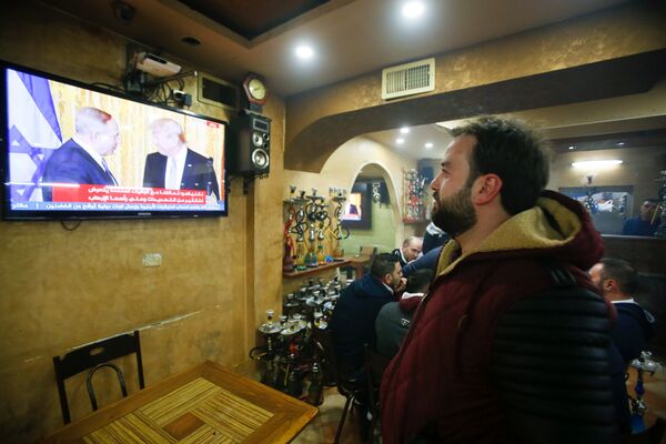 Netanyahu ile Trump'ın Beyaz Saray'daki ortak basın toplantısı Filistin'de de canlı olarak yayınlandı. Fotoğraf, İsrail'in 1967'den bu yana işgal altına tuttuğu Batı Şeria'nın El Halil kentinde çekildi. - Sputnik Türkiye